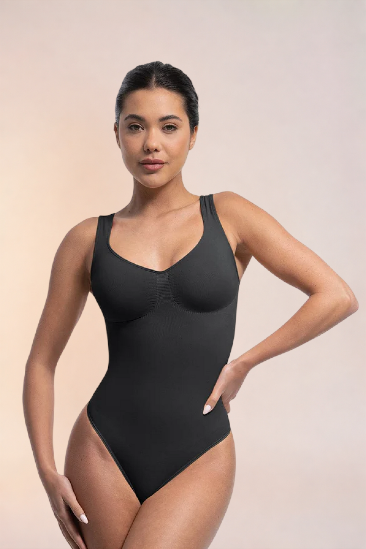 Skinzform Diamant Bodysuit in Noir, front view on the model with a hand on the hip