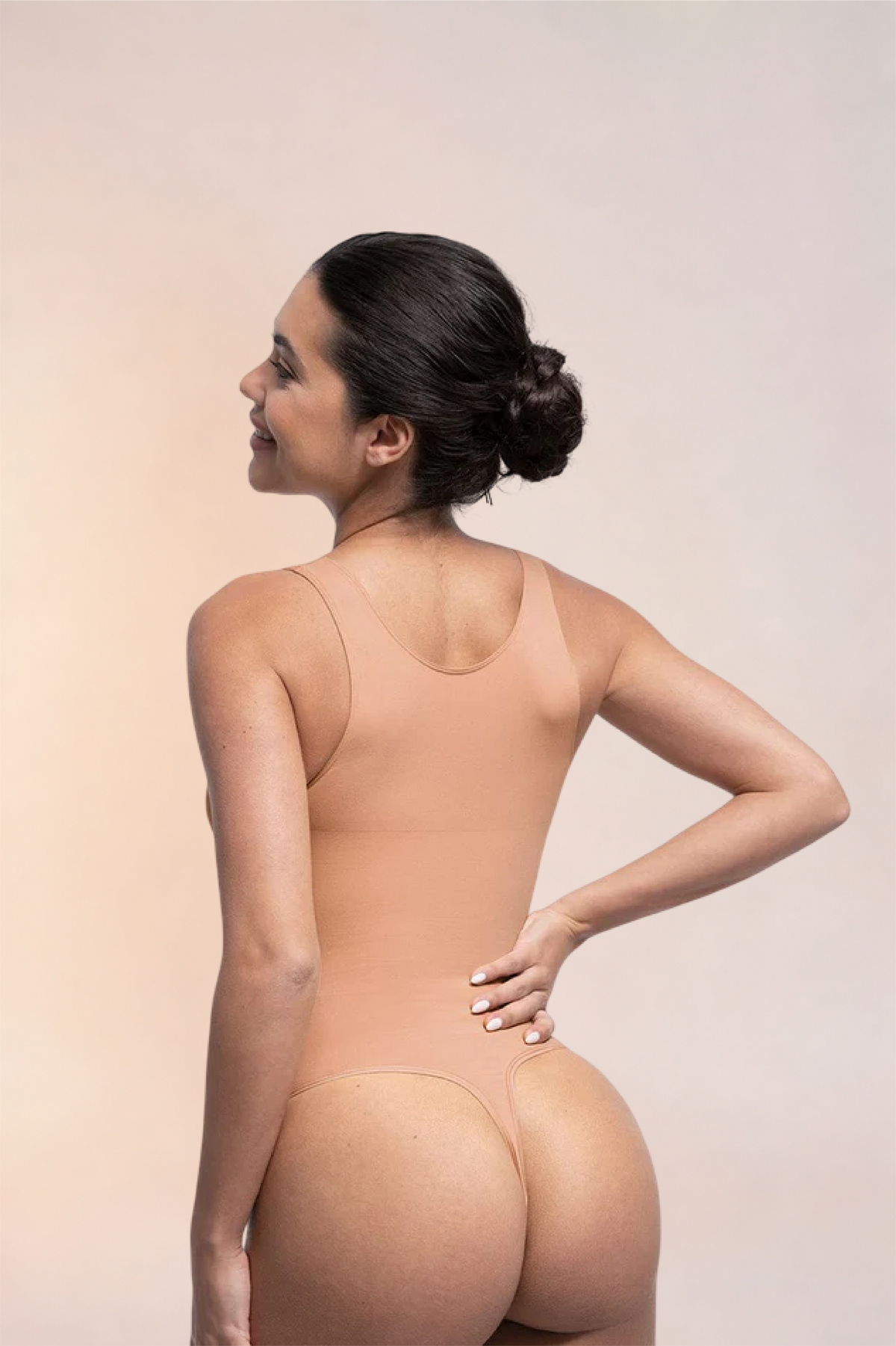 Skinzform Diamant Bodysuit in Nude, back view - model looking over one shoulder
