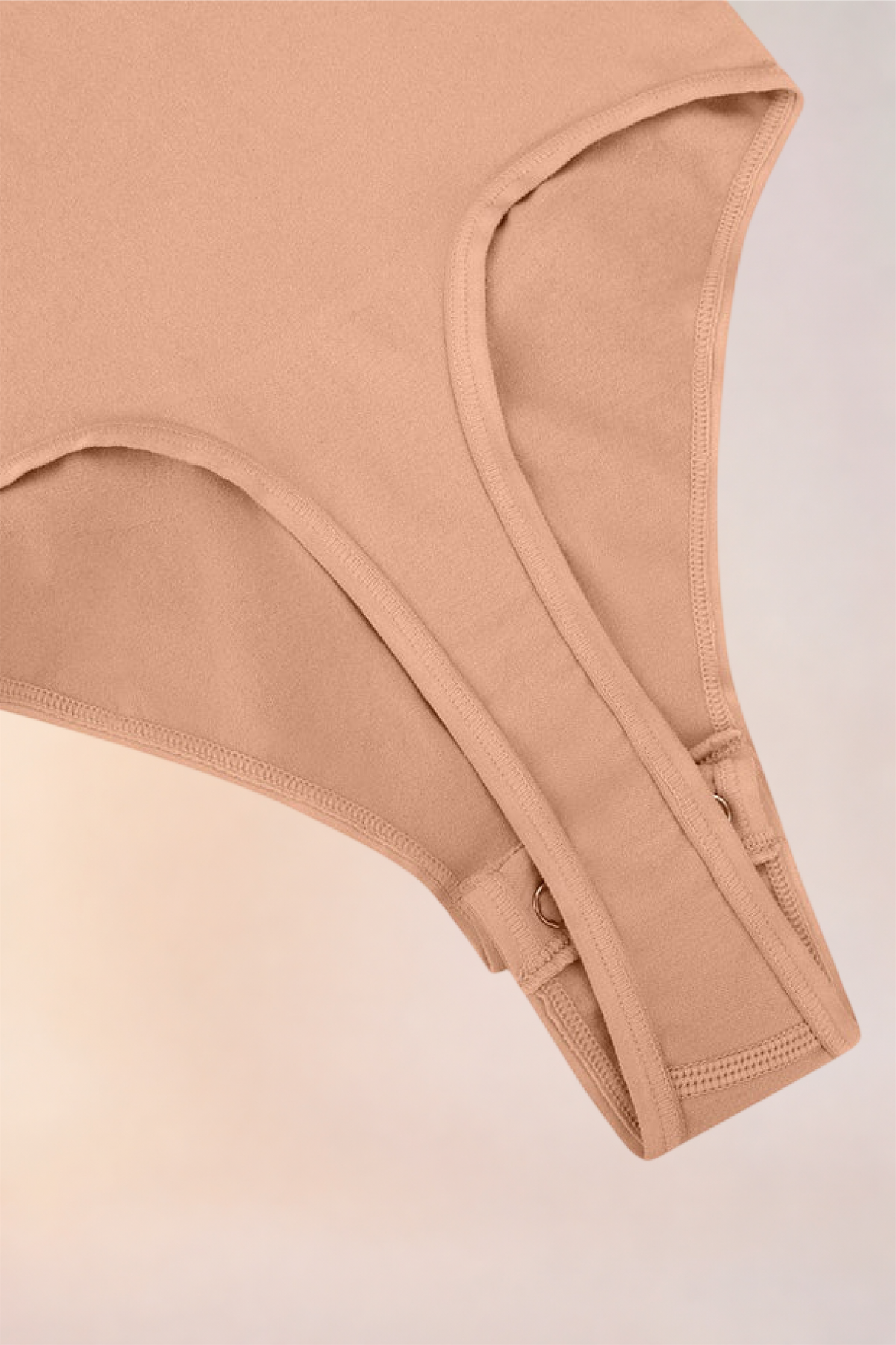 Flat lay of the Skinzform Diamant Bodysuit in Nude showing the snap gusset