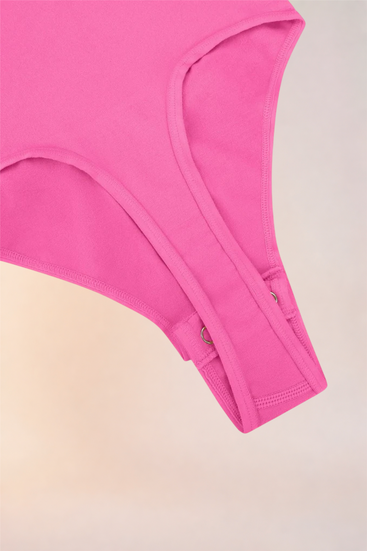 Flat lay of the Skinzform Diamant Bodysuit in Rose showing the snap gusset
