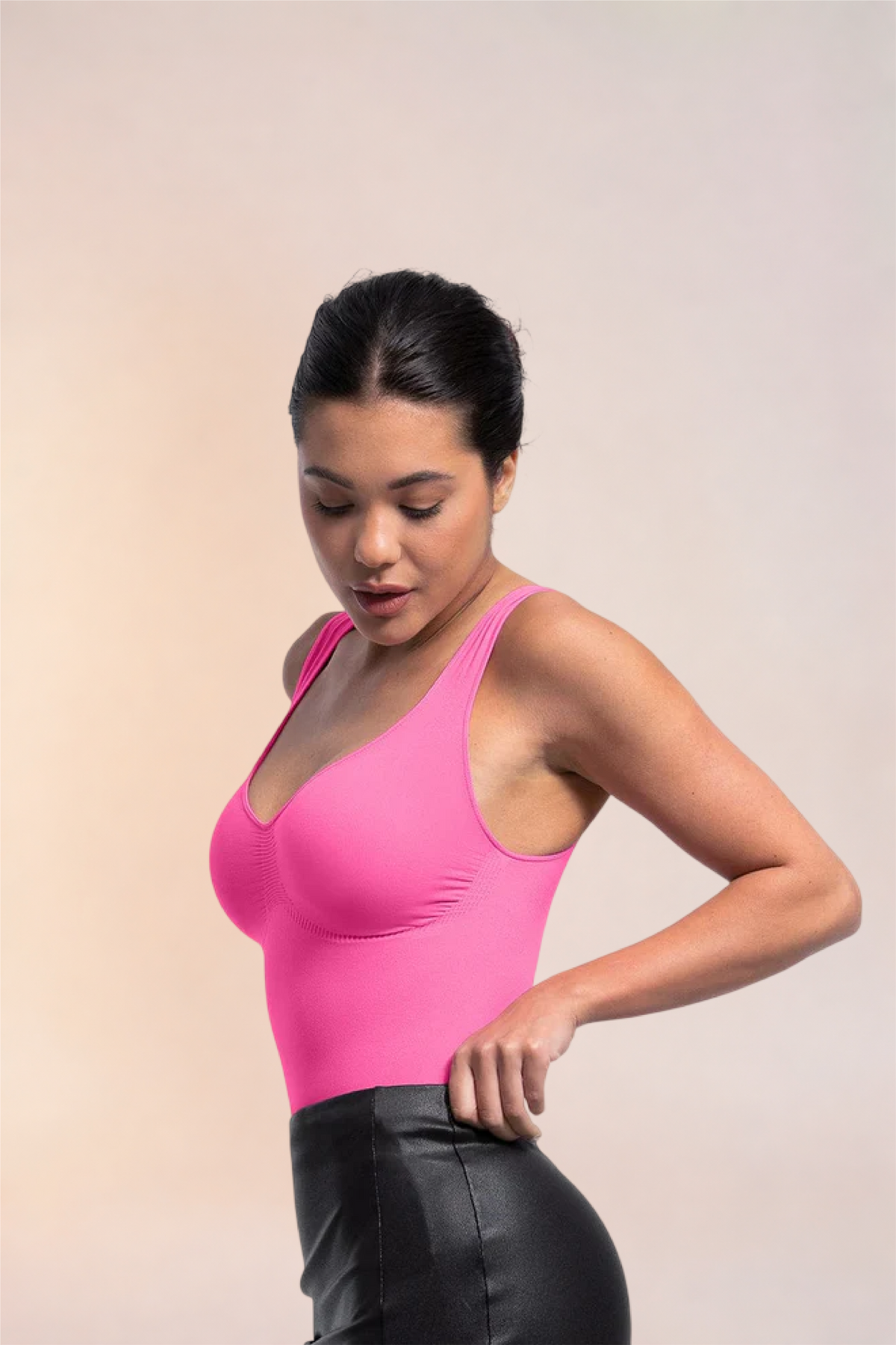 Skinzform Diamant Bodysuit in Rose styled with a black leather skirt, model looking down