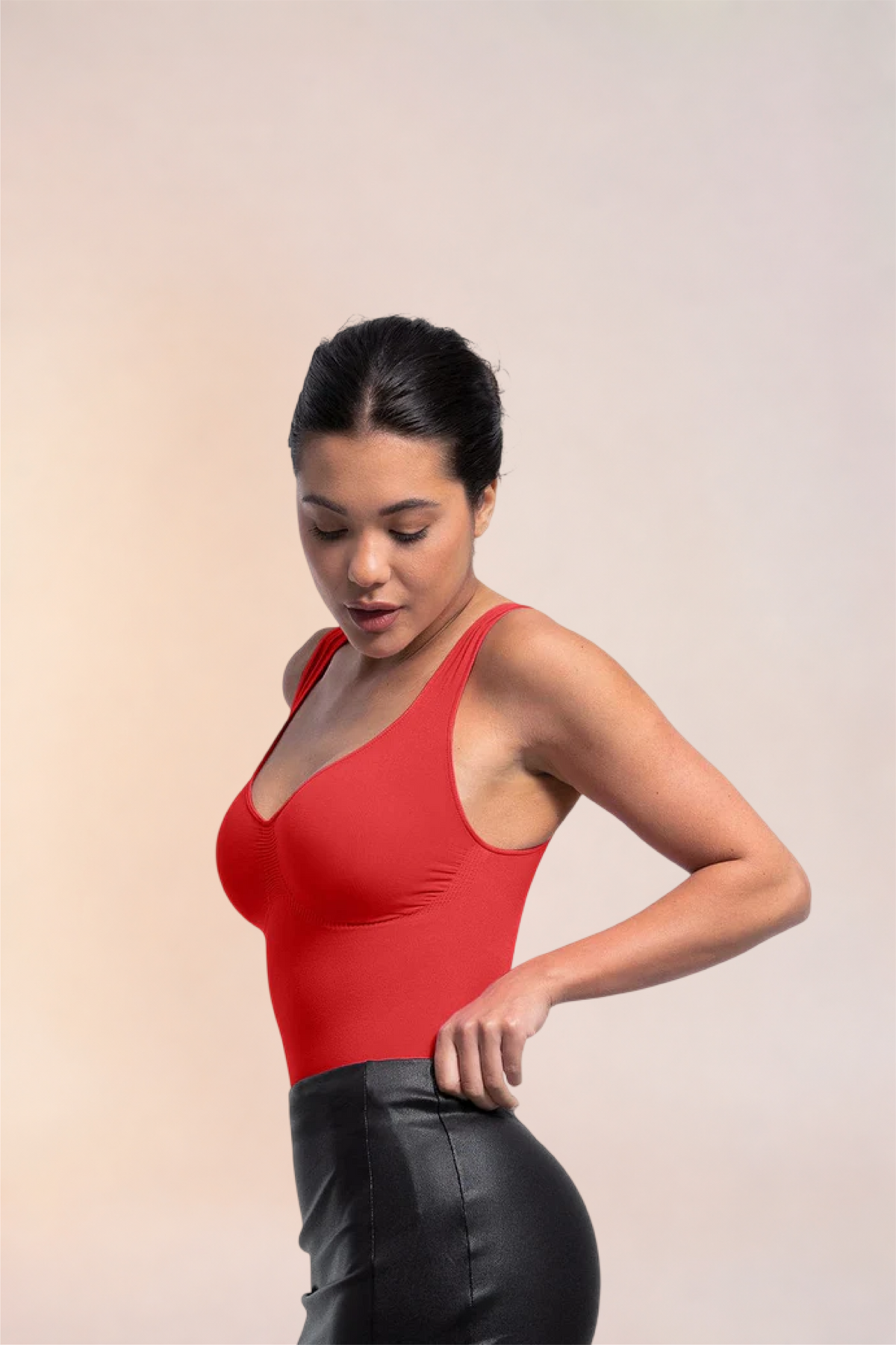 Skinzform Diamant Bodysuit in Rouge styled with a black leather skirt, model looking down