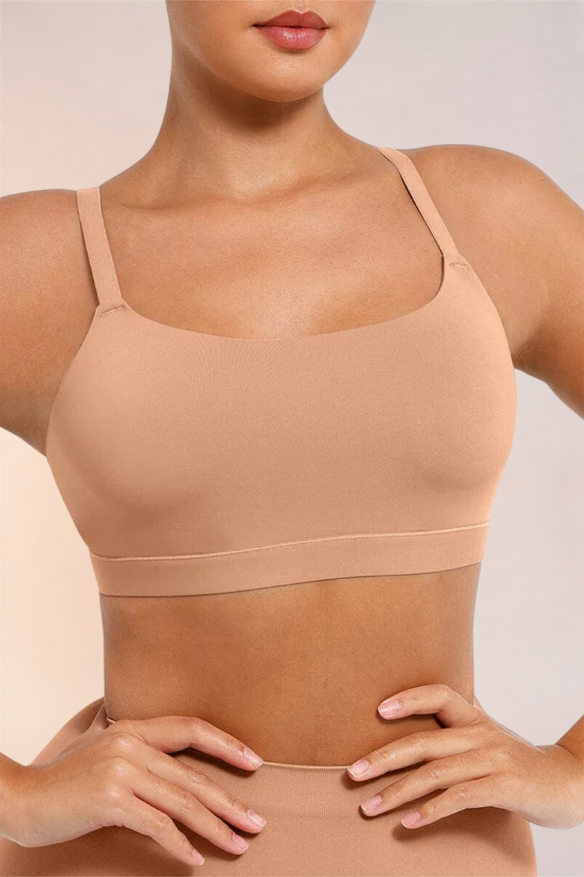 Skinzform Doux Bralette in Beige - half-length front view, hands at the waist