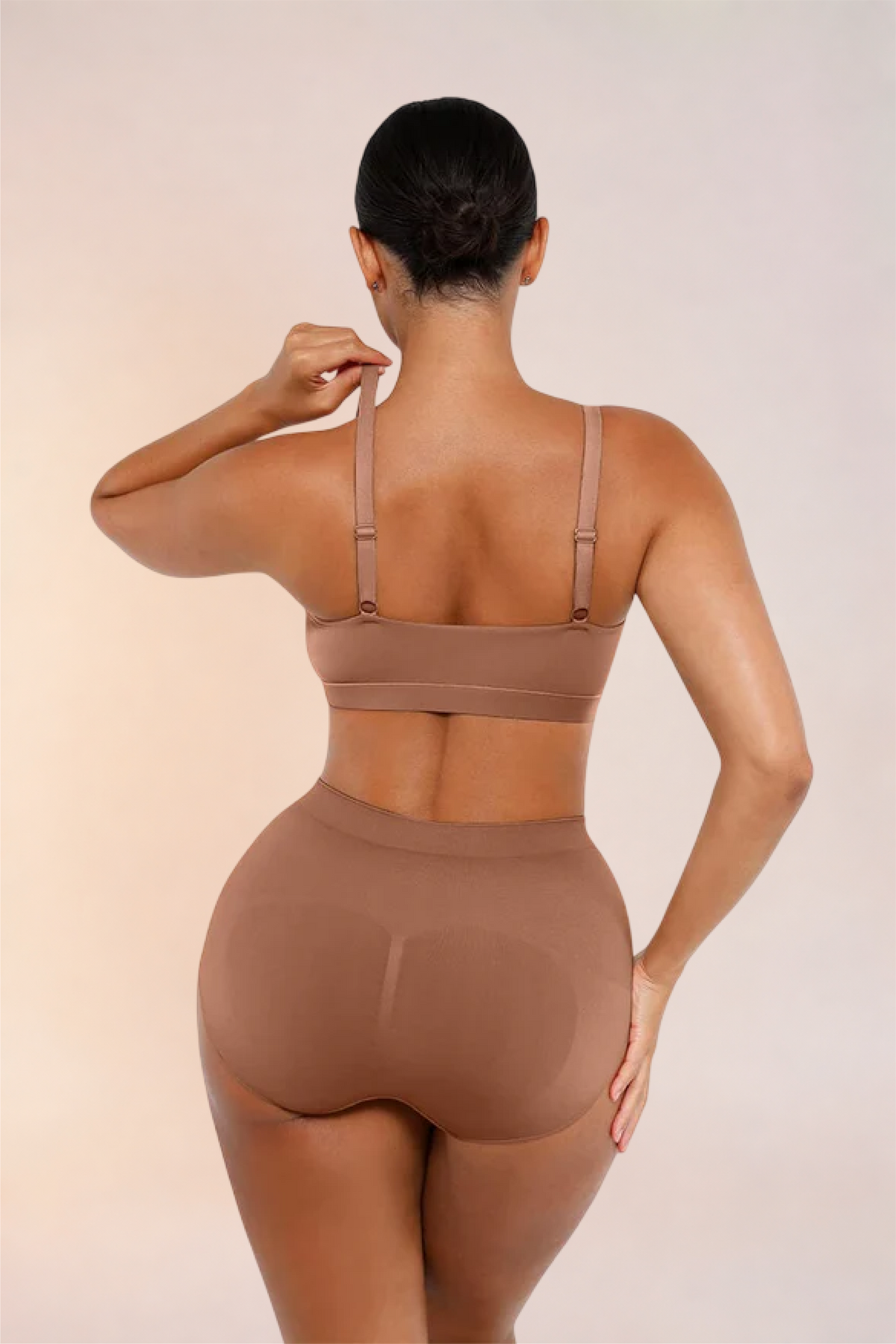Skinzform Doux Bralette in Latte, back view - model lifting one adjustable strap