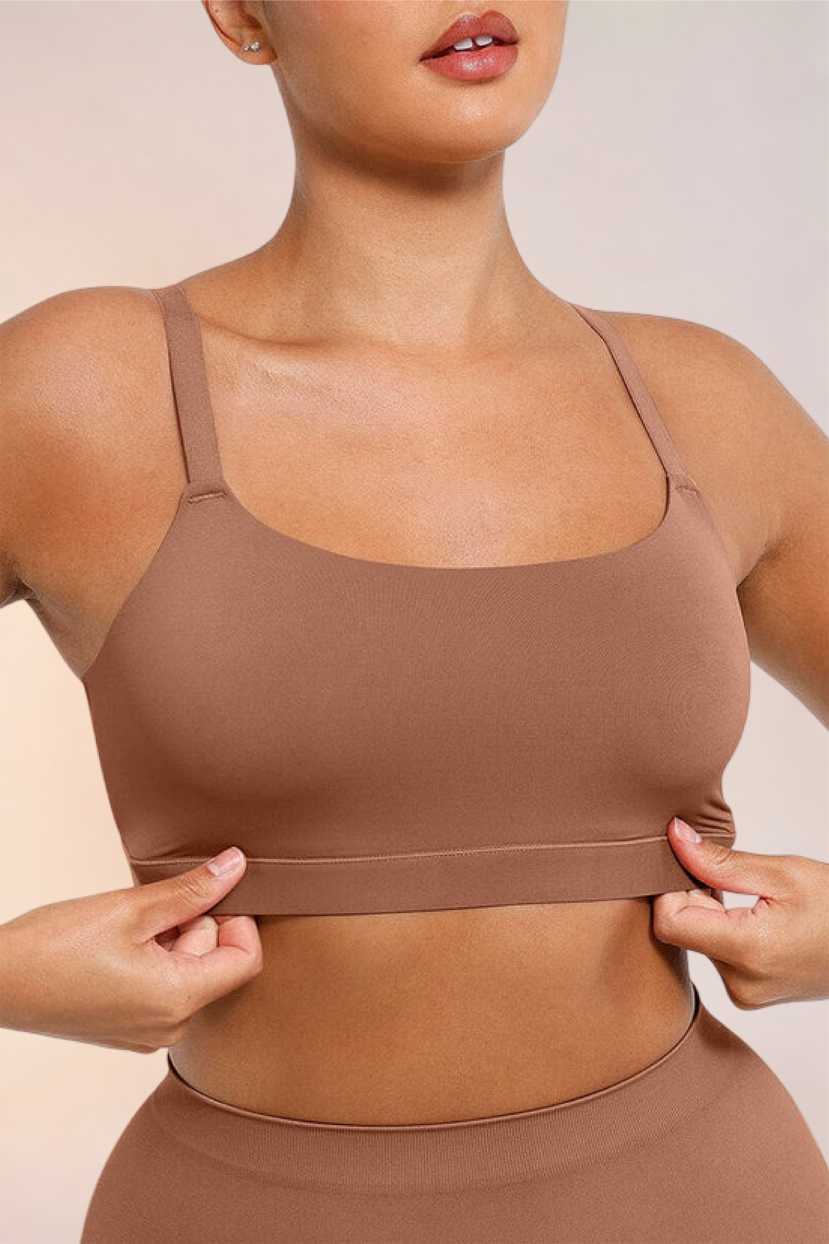Skinzform Doux Bralette in Latte - model easing the underband into place