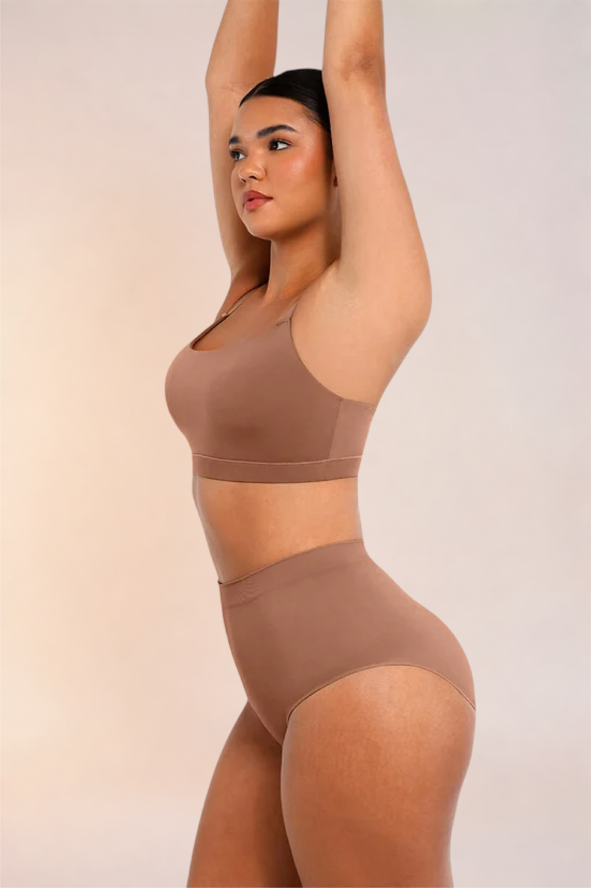 Skinzform Doux Bralette in Latte worn with matching briefs, side view with arms raised