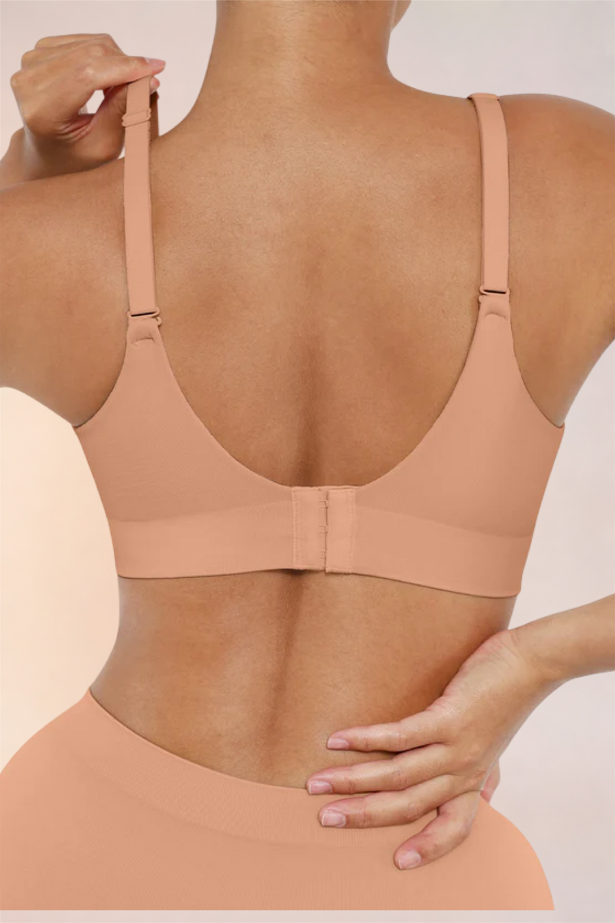 Skinzform Nuage Bra in Dark Skin - model adjusting the strap at the back
