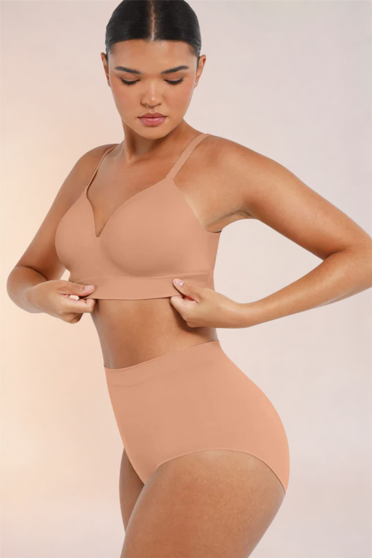 Skinzform Nuage Bra in Dark Skin - model smoothing the underband at the waist