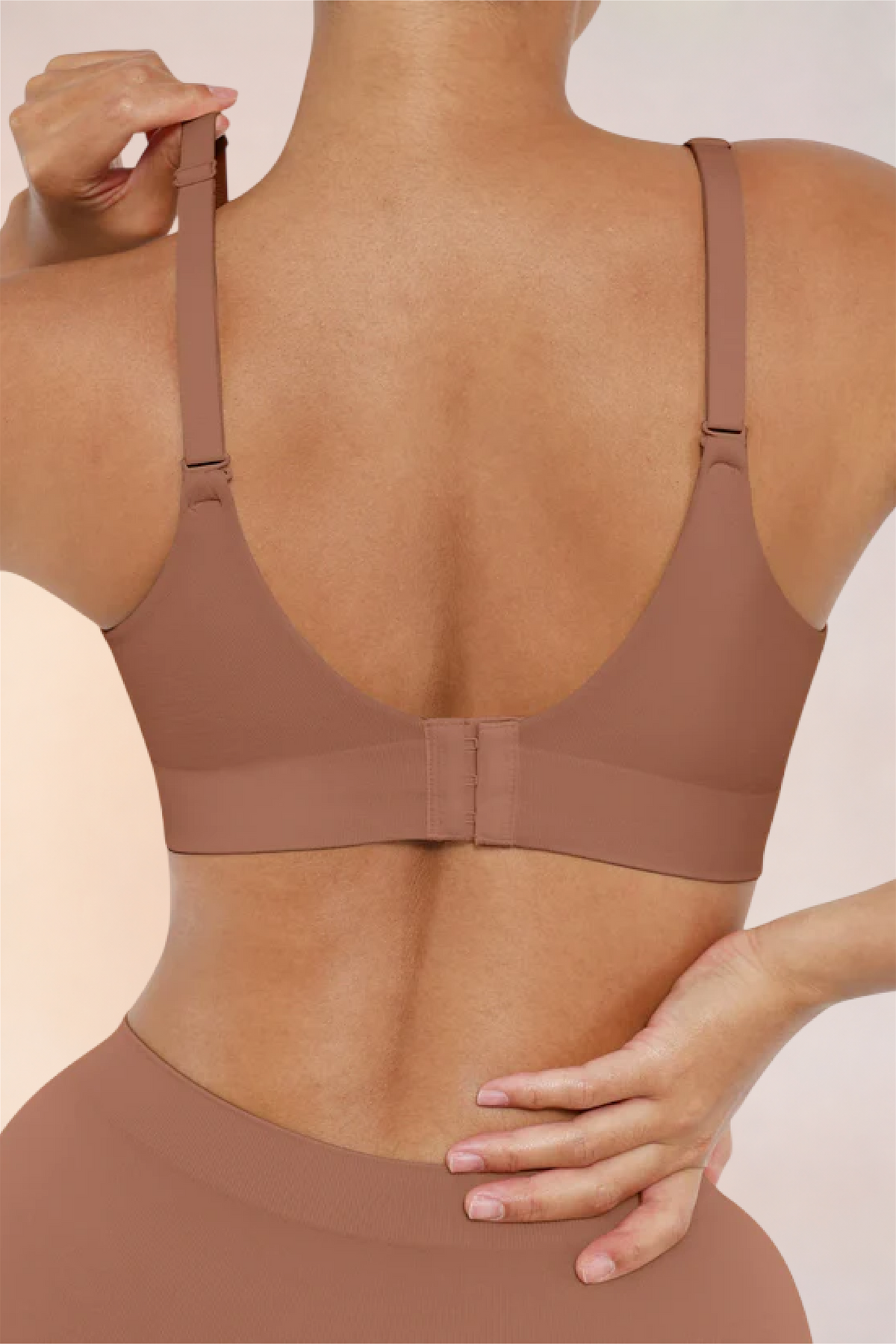 Skinzform Nuage Bra in Latte - model adjusting the strap at the back
