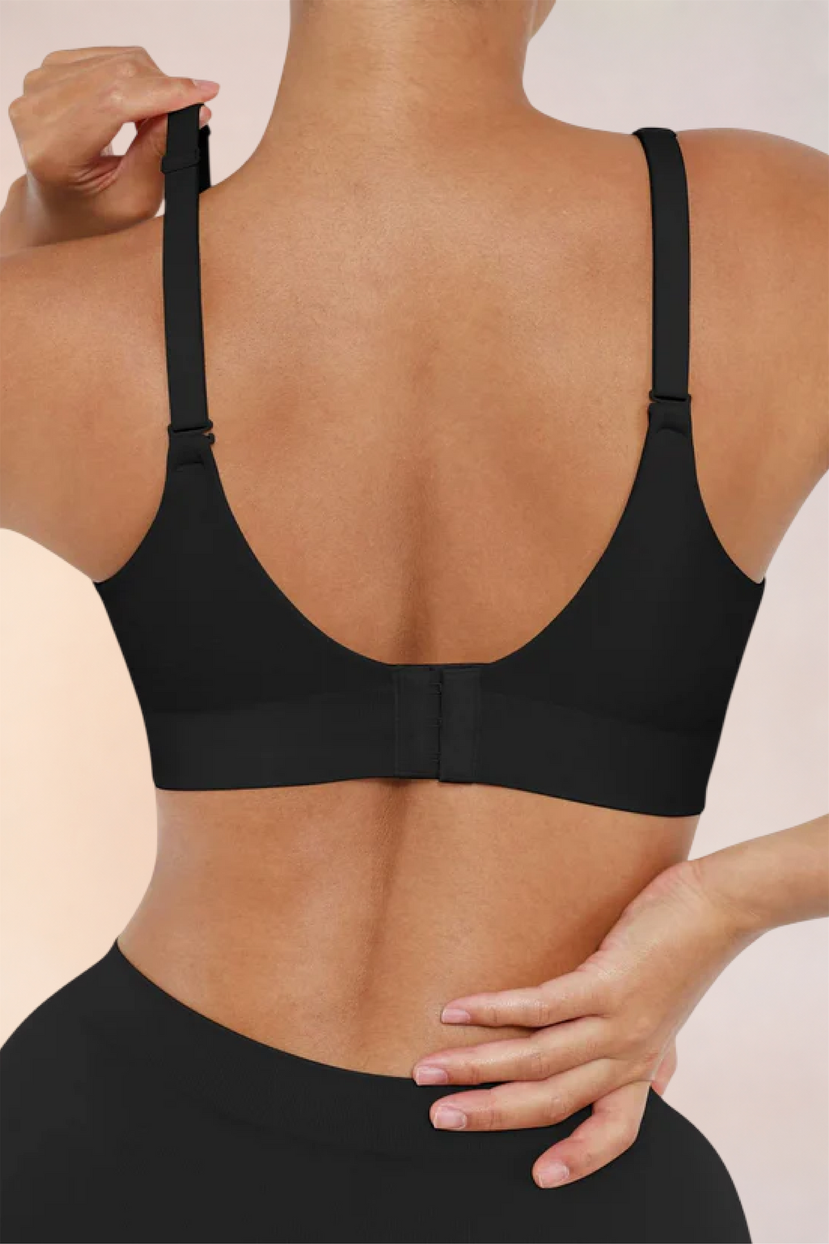 Skinzform Nuage Bra in Noir - model adjusting the strap at the back