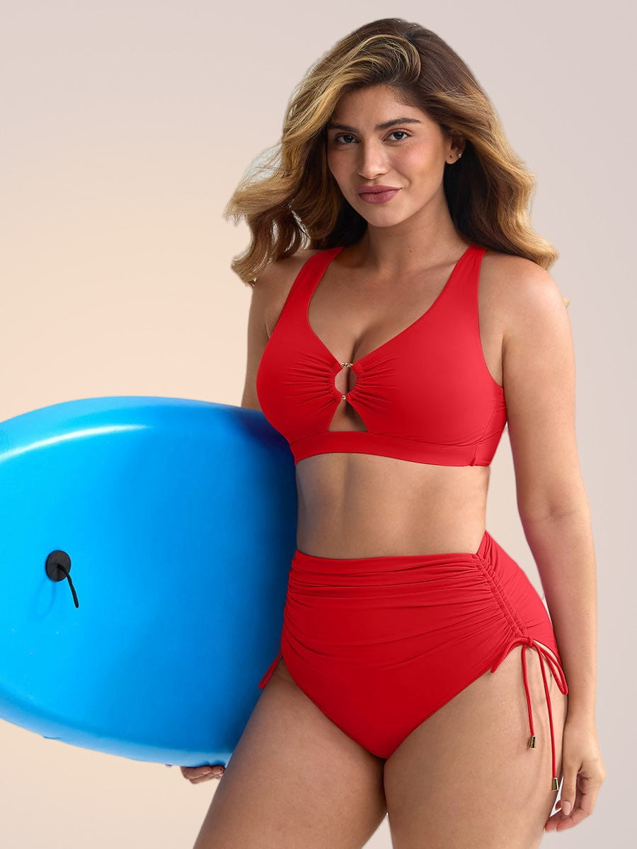 Skinzform Riviera in Red - model holding a blue inflatable ball, half-length front view
