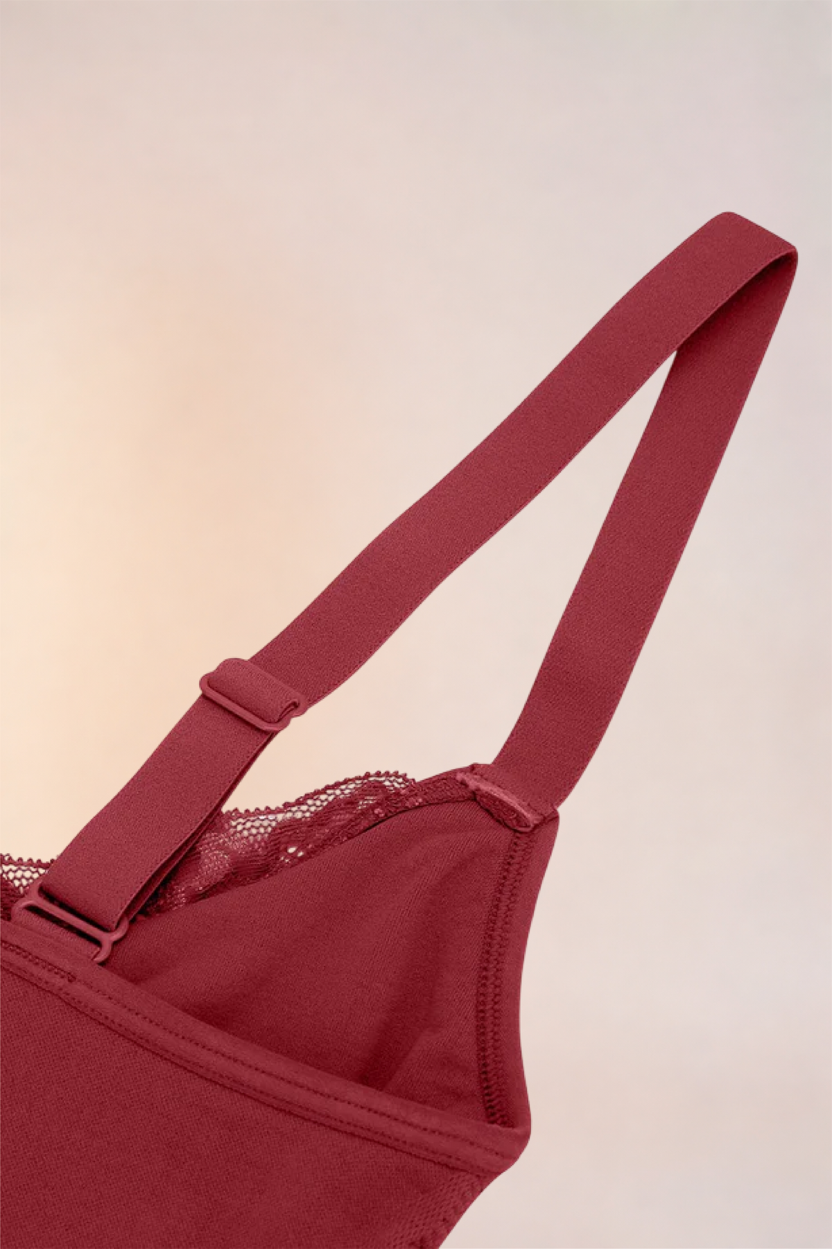 Flat lay of the Skinzform Scoop Bralette in Red showing the strap and lace-trimmed cup