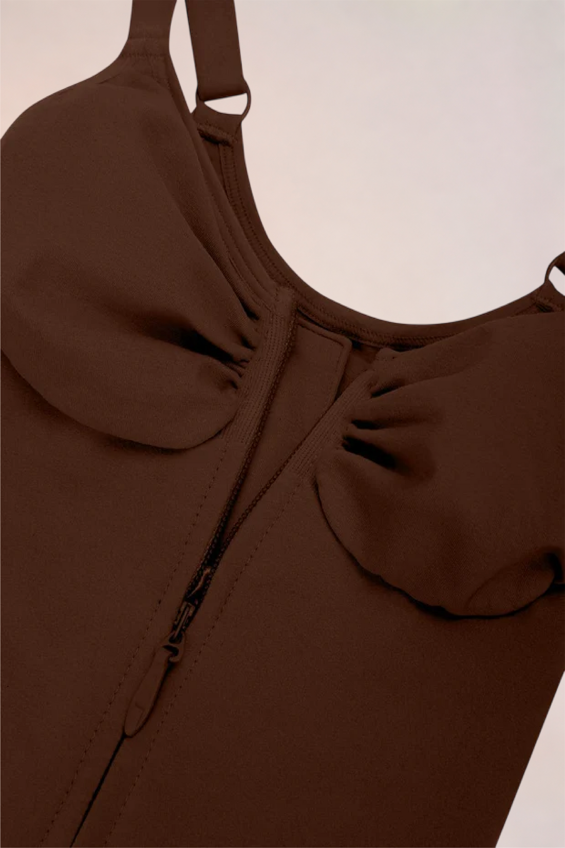 Skinzform Séjour Bodysuit in Cacao - model opening the front zip